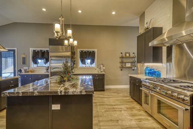 kitchen with a kitchen island, pendant lighting, range hood, backsplash, and high end appliances