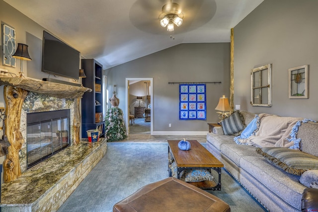 carpeted living room with built in shelves, ceiling fan, a premium fireplace, and vaulted ceiling