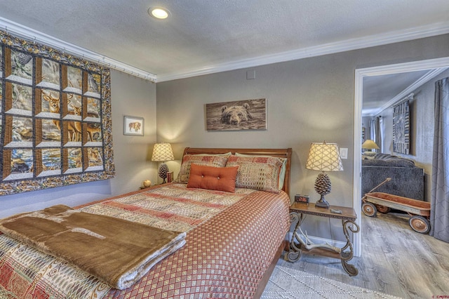 bedroom with light hardwood / wood-style flooring, ornamental molding, and a textured ceiling