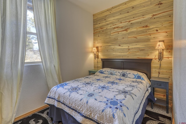 bedroom featuring wooden walls