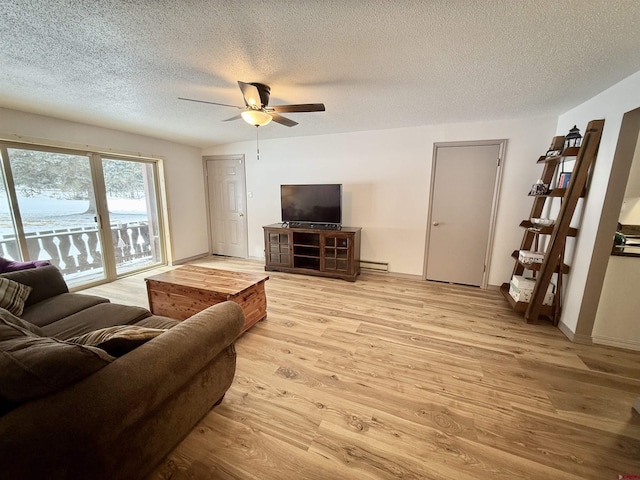 living room featuring ceiling fan, a baseboard radiator, a textured ceiling, and light wood-type flooring