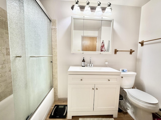 full bathroom featuring vanity, bath / shower combo with glass door, and toilet