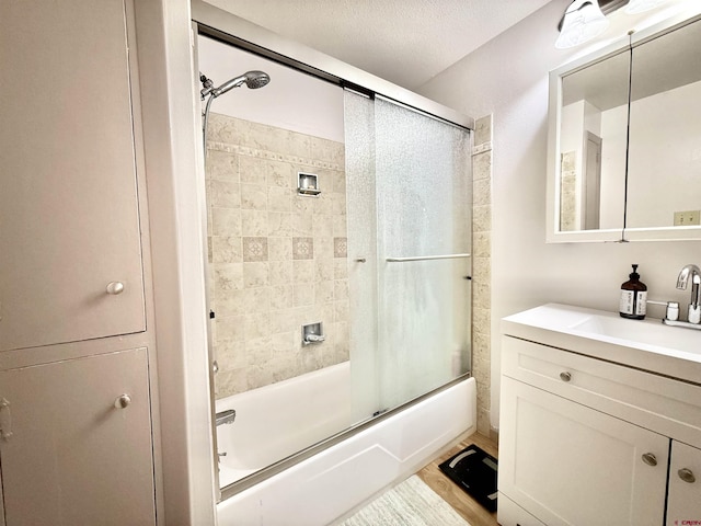 bathroom with vanity, shower / bath combination with glass door, and a textured ceiling