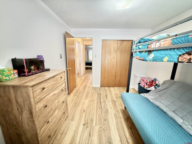 bedroom with a textured ceiling and light wood-type flooring