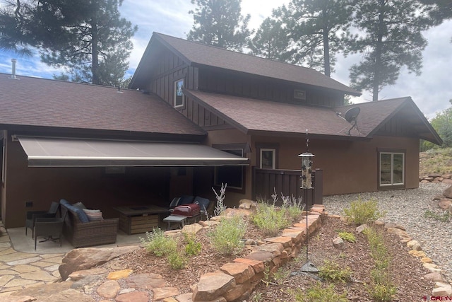 rear view of house with an outdoor hangout area, a garage, and a patio area