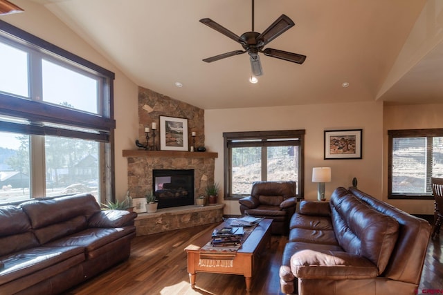 living room featuring lofted ceiling, hardwood / wood-style flooring, a stone fireplace, and ceiling fan