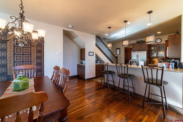 dining space featuring sink, a notable chandelier, and dark hardwood / wood-style flooring