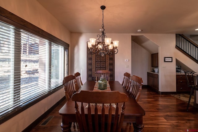 dining room featuring a notable chandelier and dark wood-type flooring