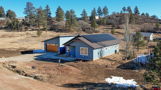 view of front facade featuring a garage and solar panels