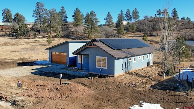 view of front of home featuring a garage and solar panels