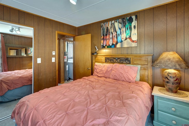 bedroom featuring carpet flooring and wooden walls