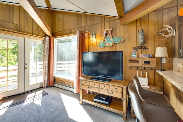 carpeted living room featuring vaulted ceiling with beams, wooden walls, french doors, and baseboard heating