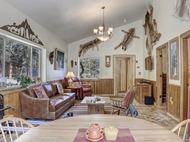 living room featuring vaulted ceiling, wooden walls, a chandelier, and carpet flooring