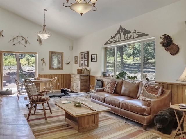 living room featuring lofted ceiling and wood walls