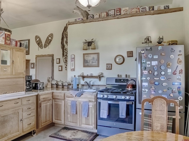 kitchen with sink, light tile patterned floors, stainless steel appliances, and light brown cabinets