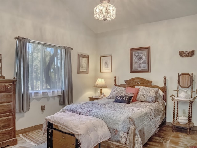 bedroom featuring lofted ceiling, an inviting chandelier, and light wood-type flooring