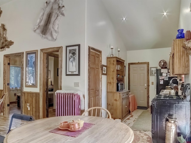 dining room featuring radiator heating unit and high vaulted ceiling