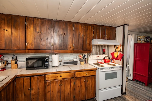 kitchen featuring dark hardwood / wood-style flooring, tile counters, tasteful backsplash, and white range with electric stovetop