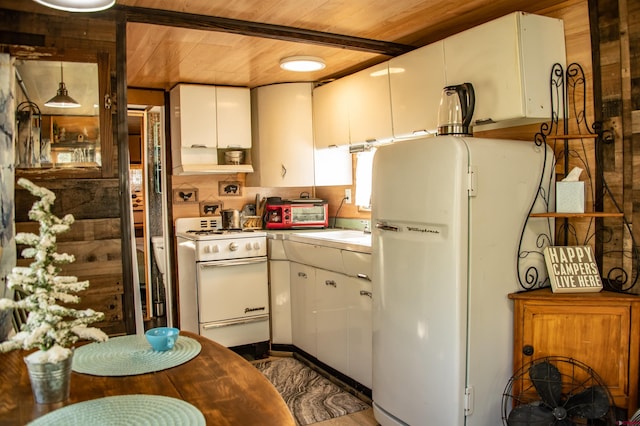 kitchen featuring refrigerator, wood walls, white cabinetry, white stove, and wooden ceiling