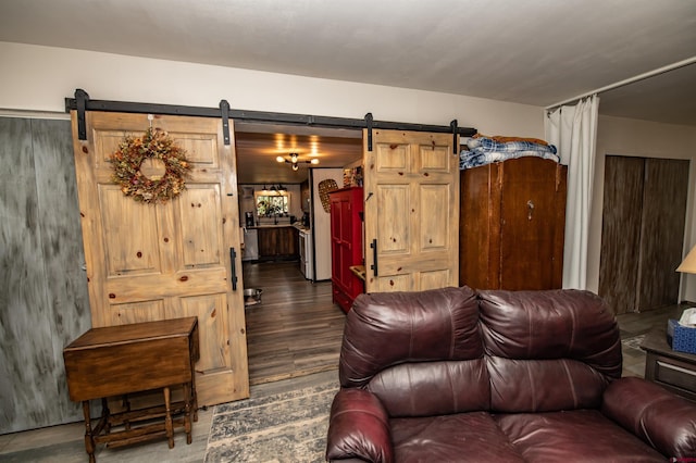 living room with dark wood-type flooring and a barn door