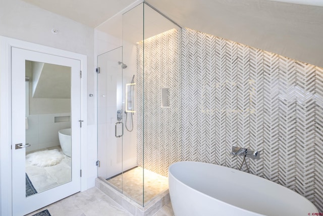 bathroom featuring tile walls and plus walk in shower