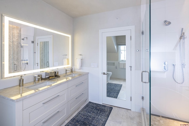 bathroom featuring vanity, a shower with door, and toilet