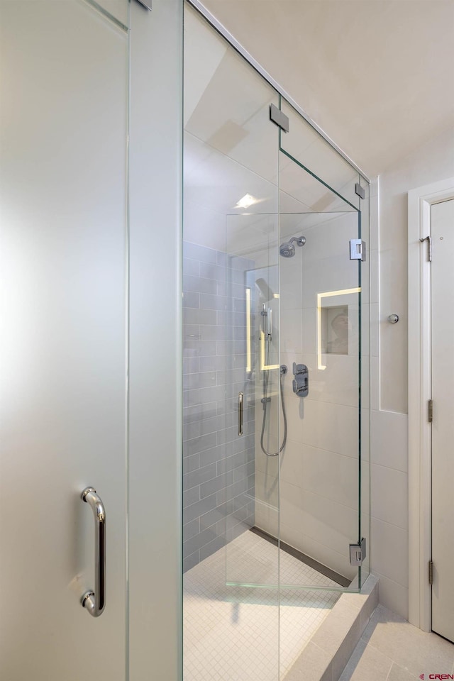 bathroom featuring tile patterned floors and a shower with shower door