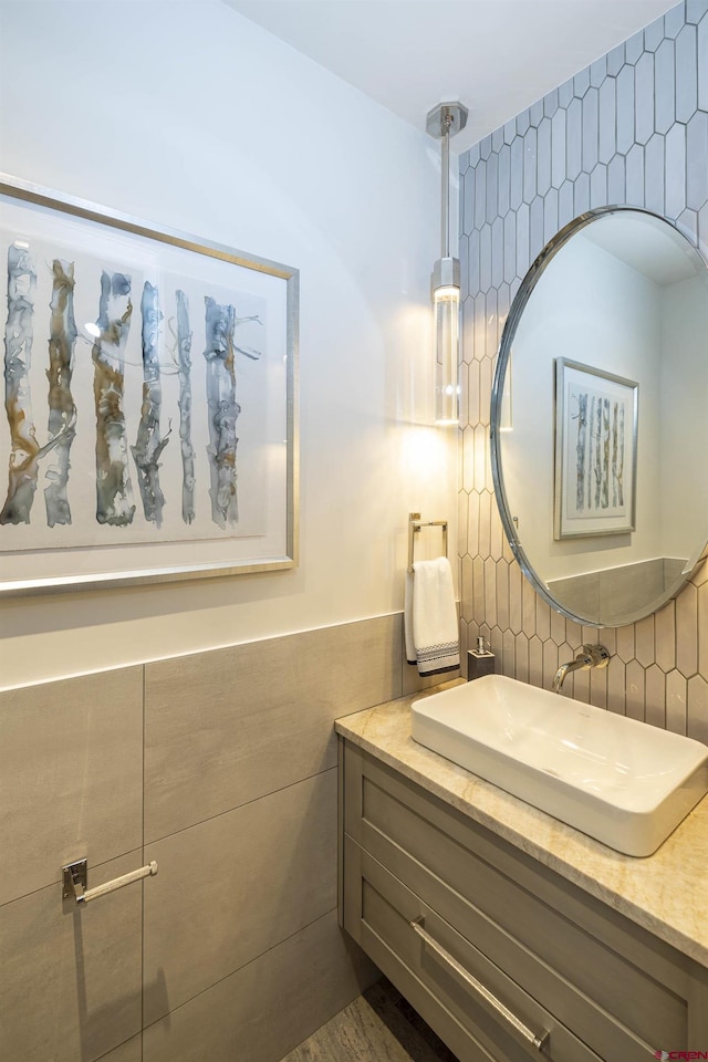 bathroom featuring vanity and tile walls