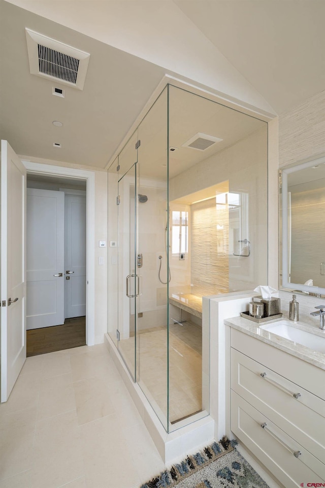 bathroom with lofted ceiling, vanity, tile patterned flooring, and a shower with door