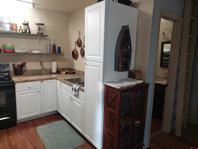 kitchen with stone countertops, white cabinetry, sink, dark hardwood / wood-style flooring, and black / electric stove