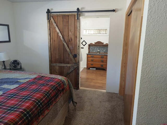 bedroom with a barn door and carpet