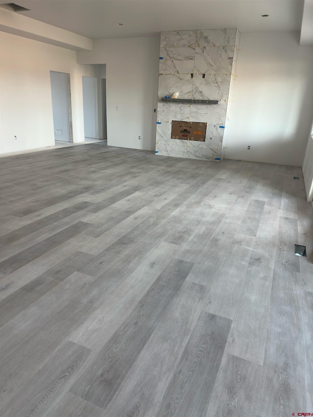 unfurnished living room featuring a high end fireplace and wood finished floors