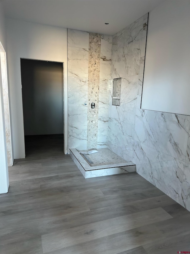 bathroom featuring a marble finish shower