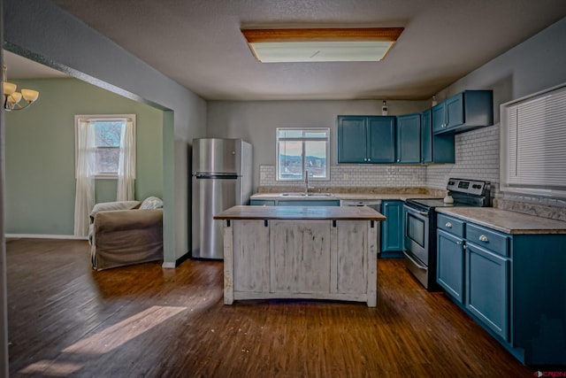 kitchen with blue cabinetry, sink, appliances with stainless steel finishes, dark hardwood / wood-style floors, and backsplash