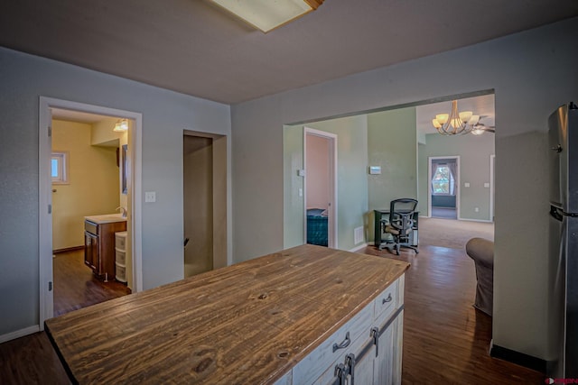 kitchen featuring wooden counters, decorative light fixtures, stainless steel refrigerator, dark hardwood / wood-style floors, and a notable chandelier