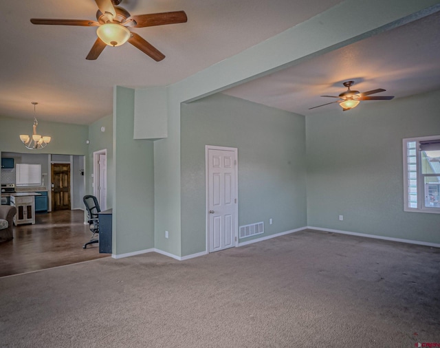 carpeted spare room featuring ceiling fan with notable chandelier