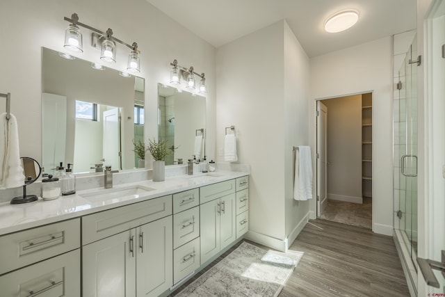 bathroom featuring a shower with door, vanity, and hardwood / wood-style floors