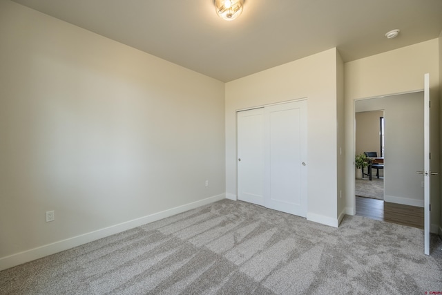 unfurnished bedroom featuring light colored carpet and a closet