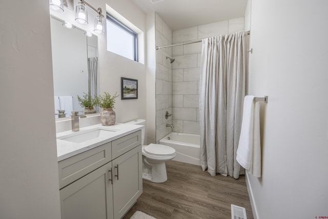 full bathroom with hardwood / wood-style flooring, vanity, shower / bath combo, and toilet