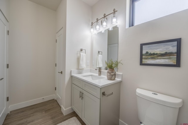 bathroom featuring vanity, toilet, and hardwood / wood-style floors