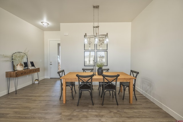 dining space featuring dark hardwood / wood-style flooring and a chandelier