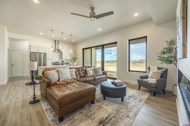 living room with ceiling fan and light hardwood / wood-style floors