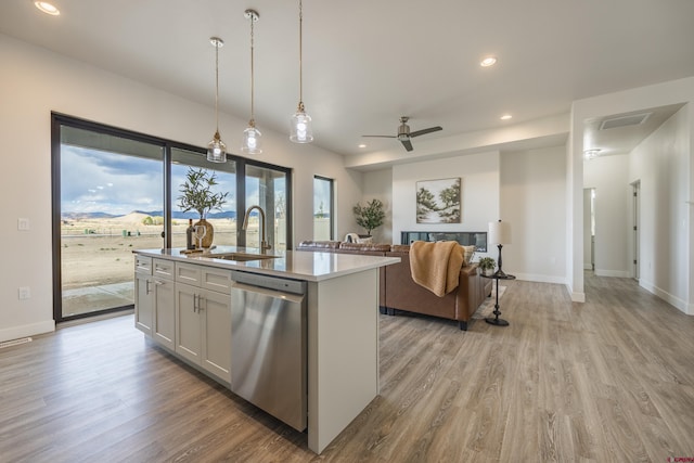 kitchen featuring dishwasher, a kitchen island with sink, sink, and white cabinets