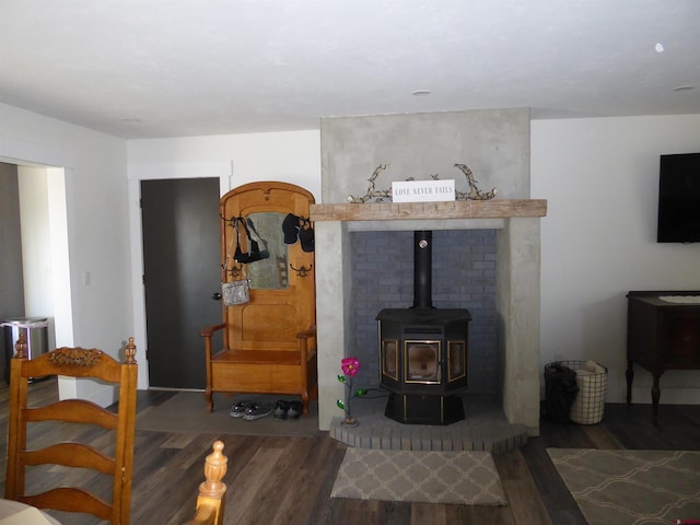 living room with dark hardwood / wood-style flooring and a wood stove