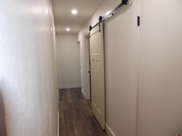 hallway with dark hardwood / wood-style floors and a barn door