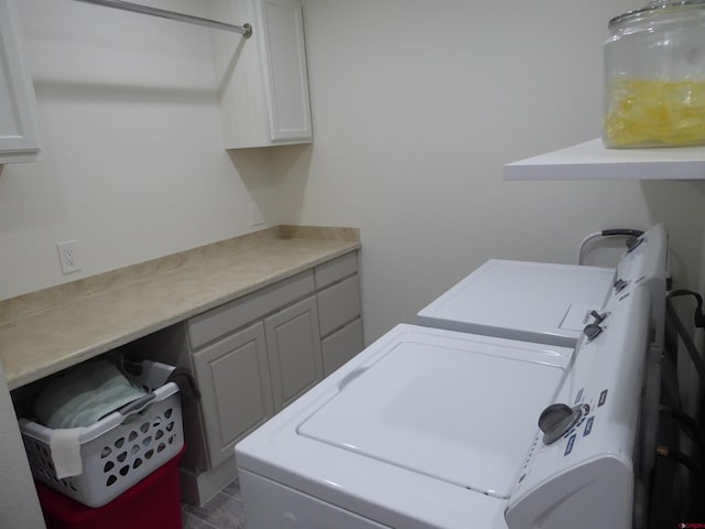 laundry room featuring cabinets and washer and dryer