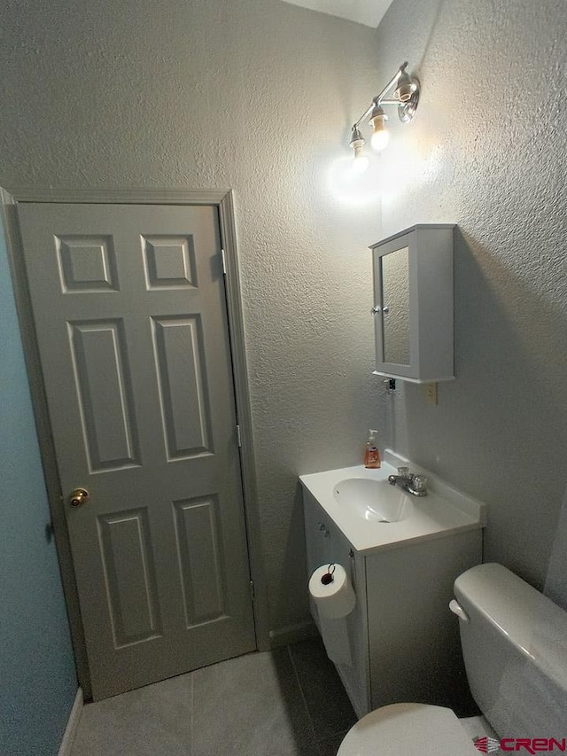 bathroom featuring vanity, tile patterned floors, and toilet