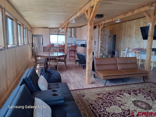 living room with wood walls, hardwood / wood-style floors, and wooden ceiling