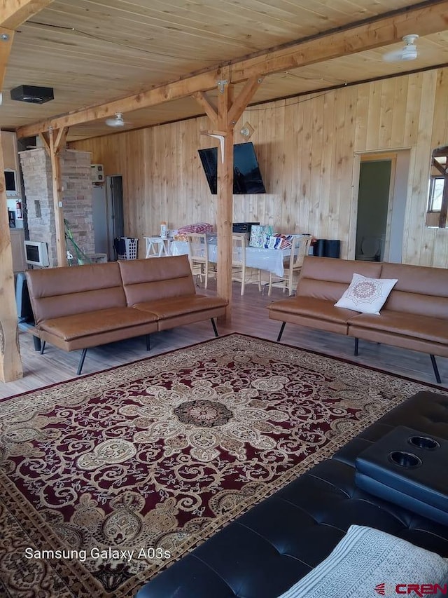 living room featuring wood ceiling, wooden walls, beamed ceiling, and hardwood / wood-style flooring