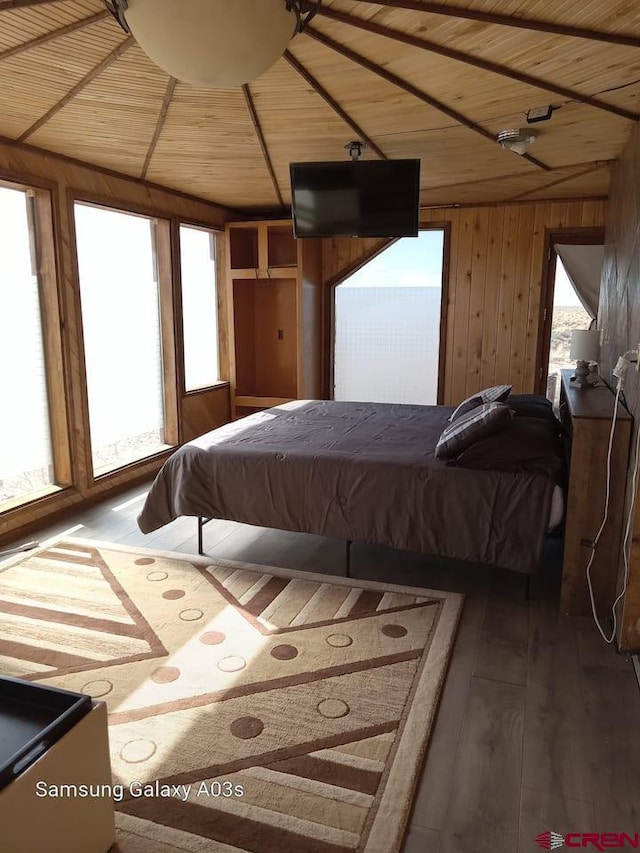 bedroom featuring dark wood-type flooring, wood walls, and wooden ceiling